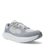 Championes Under Armour modelo Versurge, color gris con detalles en amarillo neón. Presentan una parte superior que combina malla textil con revestimientos de gamuza sintética, entresuela con tecnología Charged Cushioning para mayor amortiguación y suela de goma flexible.