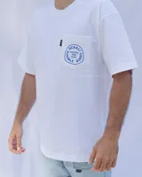 Remera blanca de algodón con cuello redondo y bolsillo en el pecho con logo estampado en azul.