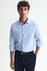 Camisa H&M de corte slim fit en mezcla de algodón con rayas finas celestes y blancas. Presenta cuello italiano, cierre frontal con botones y mangas largas.