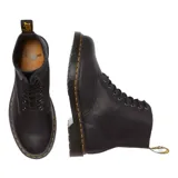 Botas de caña media Dr. Martens modelo 1460 Pascal, confeccionadas en cuero granulado negro. Presentan cierre mediante cordones, suela de goma con cámara de aire y el característico pespunte amarillo en el borde.