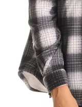 Sobrecamisa de tejido soft con interior afelpado, diseño a cuadros en tonos azules y blancos, cuello con solapa, cierre frontal con botones y bolsillos aplicados en el pecho.