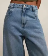 Pantalón de jean estilo skater con lavado dirty, tiro bajo, trabillas anchas en la cintura, cierre frontal con botón y cremallera, y bolsillos funcionales en frente y espalda.