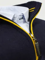 Sweater azul marino de hilo con medio cierre frontal con cremallera y detalles en rojo en cuello y puños.