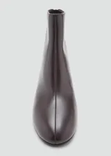 Botín de cuero vacuno color marrón oscuro con tacón bloque de 5,5 cm y cierre de cremallera en la parte posterior. Presenta punta redonda y diseño minimalista.