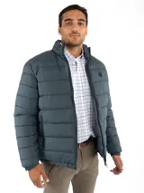 Campera puffer reversible color verde azulado con interior gris. Tiene cuello alto, cierre frontal y bolsillos laterales con cierre.