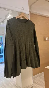 Sweater negro de punto con diseño de ochos, cuello redondo y mangas largas.