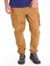 Pantalón cargo color tostado, con bolsillos laterales tipo cargo, cintura elástica y puños elásticos en los tobillos.