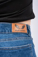 Jean mom de tiro alto con corte recto, confeccionado en denim azul clásico. Presenta cierre frontal con botón y bolsillos laterales y traseros.
