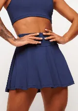 Pollera short deportiva azul marino con calza incorporada, bolsillos laterales y protección UV 50+.