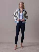 Campera combinada marca Nanette, con torso y mangas en tejido a rayas horizontales blancas y negras. Solapa, puños y cierre en denim celeste. Cierre frontal con botones metalizados.