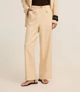 Pantalón wide leg de cintura alta color beige, confeccionado con lino y viscosa. Incluye cinturón elástico con hebilla metalizada.