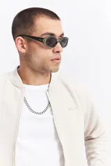 Campera tipo bomber color beige, con cierre frontal completo, cuello redondo y puños elásticos. Presenta una textura sutil en la tela y un calce cómodo.