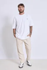 Remera de algodón color verde oliva, corte oversize, con cuello redondo y un pequeño logo bordado en el pecho.