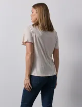 Remera color beige de tejido melange con escote en V y aplique de crochet en el frente.