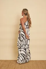 Vestido largo con diseño one-shoulder, una manga larga acampanada y estampado abstracto en color blanco y negro.