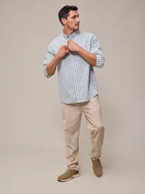 Camisa de manga larga para hombre, confeccionada en algodón con efecto peach (textura suave). Presenta un estampado de cuadros vichy en tonos azul marino y blanco, cuello con botones y un bolsillo de parche en el pecho izquierdo.