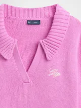 Buzo tipo polo de tejido de punto, color azul marino, con cuello solapa, escote en V y logo de la marca bordado en el pecho. Presenta mangas largas y un diseño de ruedo asimétrico con detalle acanalado.