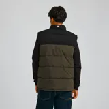 Chaleco acolchado Caterpillar con diseño bicolor en negro y verde oliva. Presenta cierre frontal completo, cuello alto, bolsillos laterales con cierre y logo de la marca estampado en el pecho.