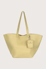 Bolso tipo shopper color amarillo con textura granulada y un monedero colgante.