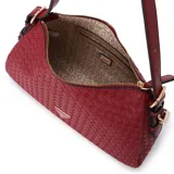 Bolso de hombro tipo baguette de color rojo intenso, con textura tejida tipo trenzado (intrecciato) en todo el cuerpo. Presenta herrajes metálicos dorados y un dije colgante con el logo triangular de Guess.