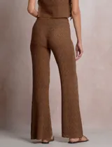 Pantalón de tiro alto con tejido calado y textura labrada, de corte recto con apertura acampanada hacia el ruedo. Cuenta con cintura elastizada y cordón de ajuste con terminaciones de caracoles decorativos.