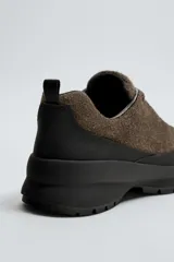 Zapatilla de cordones con parte superior de piel con acabado serraje, horma redonda, suela con volumen y piso track.