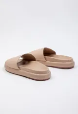 Sandalia baja blanca de símil cuero con cinta ancha sobre la capellada y plataforma de 2 cm de alto.