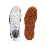 Championes Puma modelo Army Trainer, de diseño retro en color blanco con detalles en verde oscuro y suela de goma color caramelo. Presenta refuerzos de gamuza en la puntera y el logo de la marca en dorado en el lateral.
