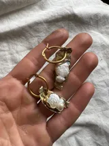 Aros tipo argolla con dije de bronce reticulado de forma irregular y piedra engarzada en el centro. Diseño artesanal con acabado texturizado.