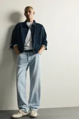 Pantalón de jean corte recto desde la cadera hasta el tobillo, con tiro medio y tejido rígido. Presenta diseño de cinco bolsillos, cierre frontal con botones y acabado en efecto lavado claro.