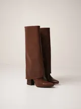 Botas negras de caña alta confeccionadas en cuero vegano, con punta fina y taco cuadrado.