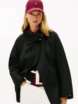 Abrigo oversize Tommy Hilfiger de mezcla de lana de doble cara en color negro, con cuello chimenea, cierre de botones dorados y bolsillos delanteros de parche.