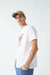 Remera verde militar de corte clásico con estampado frontal de texto en color ladrillo y dibujo de hojas.