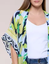 Kimono de gasa ligera con estampado floral en tonos verde, azul y celeste, de corte amplio y abierto al frente, con mangas cortas y detalle de borlas en el ruedo asimétrico.