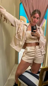 Campera color beige de gamuza sintética con flecos en mangas, espalda y ruedo.