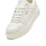Championes Puma Carina Street SD de estilo urbano, color beige, con diseño de plataforma y detalles en gamuza. Presenta el logo de la marca en el lateral y en la suela.