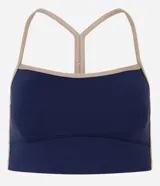Top deportivo Get Over con diseño de espalda nadador y breteles finos en color beige contrastante. Confeccionado en microfibra técnica, cuenta con copas incorporadas para mayor sujeción y ajuste al cuerpo.