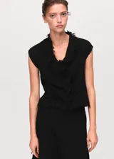 Falda corta de tejido tweed en color negro, con diseño entallado y terminaciones deshilachadas en el ruedo.