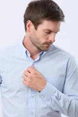 Camisa de manga larga con diseño de cuadros vichy en color verde y blanco, cuello abotonado y cierre frontal con botones.