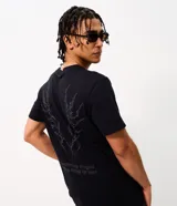 Remera masculina de algodón negro con cuello redondo, mangas cortas y corte comfort. Presenta un estampado tribal sutil en el centro del pecho.