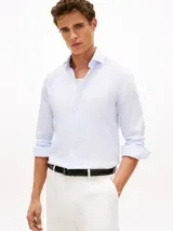 Camisa de manga larga Tommy Hilfiger color celeste con micro estampado de minipaisley, cuello clásico y cierre frontal de botones.