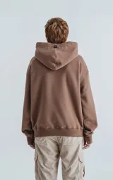 Hoodie oversize de frisa premium color cañamo (marrón claro/beige), con capucha ajustable, bolsillo canguro y puños elastizados con orificios para los pulgares.