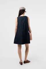 Vestido corto sin mangas de denim negro, con silueta evasé, calce suelto y costuras pespunteadas a contratono.