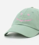 Gorra de sarga color verde con visera curva y bordado frontal con la frase "good days ahead" y detalles de flores en tono rosado.