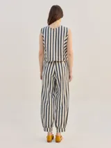 Pantalón tipo bombacha de campo color beige, de corte holgado con pinzas en la cintura y puños ajustados en los tobillos. Presenta costuras a contratono y bolsillos laterales.