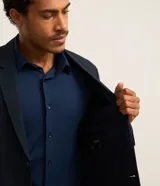 Blazer azul marino con cuello en V con solapa, abotonado doble, mangas largas y textura.