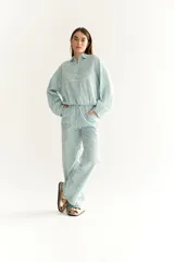 Buzo de corte oversized a rayas grises y blancas, con cuello polo y mangas largas con puños elásticos.