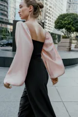 Body de escote cuadrado con cuerpo en tejido elástico negro y mangas largas abullonadas en tejido satinado color rosado con puños elásticos.