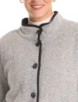 Cardigan de tejido de punto con diseño de espiga en color beige, totalmente forrado en corderito sintético blanco. Presenta cuello solapa, cierre frontal con botones, bolsillos tipo parche con solapa y terminaciones con vivos en contraste.