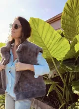 Chaleco reversible con un lado de piel sintética gris y el otro lado de tela bordada con diseño floral y espiral en tonos blanco y negro. Presenta un diseño sin mangas y corte recto.